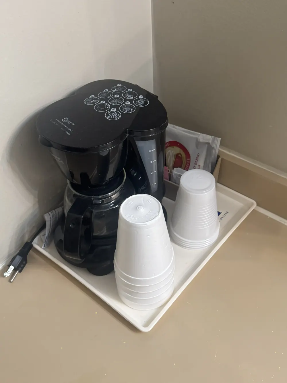 Coffee Machine with coffee packs, cups, and straws