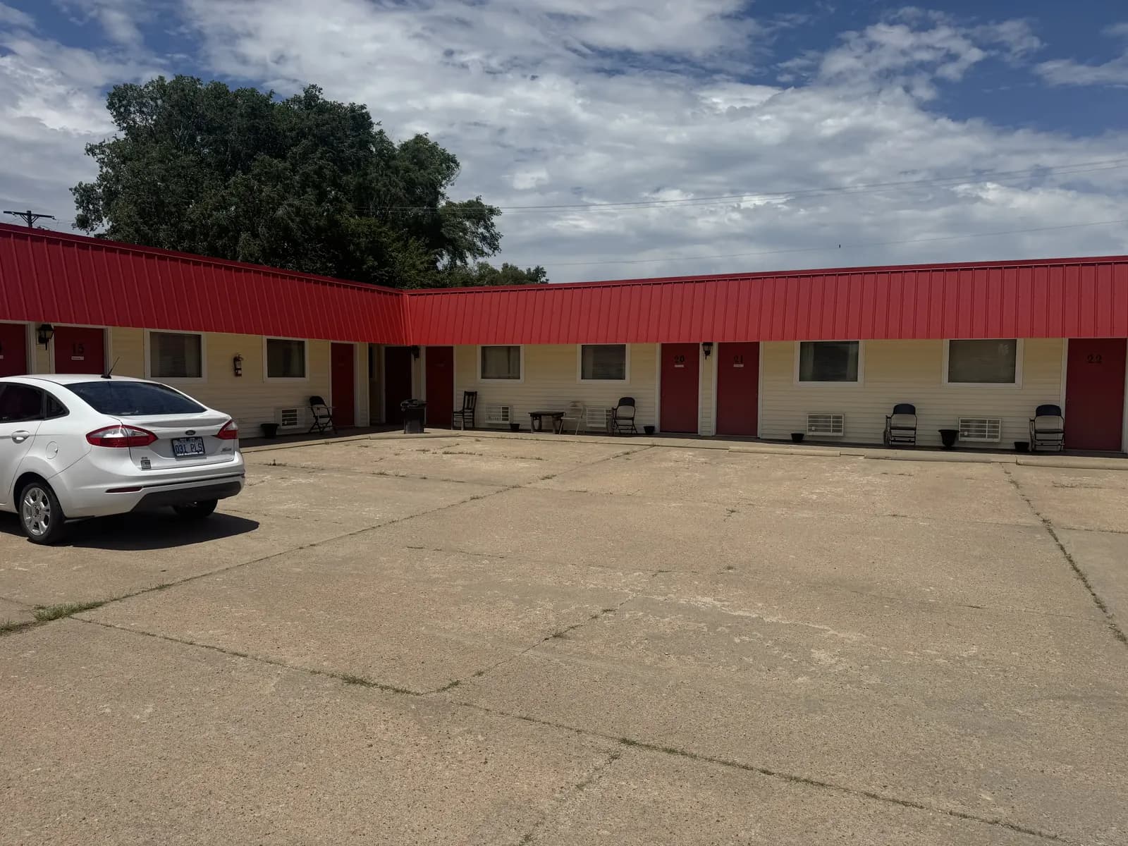 Exterior view of Rock City Motel rooms with red doors and parking.